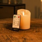 Ładowalna świeca LED z wosku DORSETTO Ø 7,5 × 10 cm z ruchomym płomieniem – na drewnianym stole z pilotem, nastrojowe tło