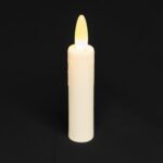 Ładowalna LED świeca stołowa DORSETTO 97 mm w kolorze białym z jasnożółtym, świecącym płomieniem, ustawiona pionowo na jednolitym czarnym tle.