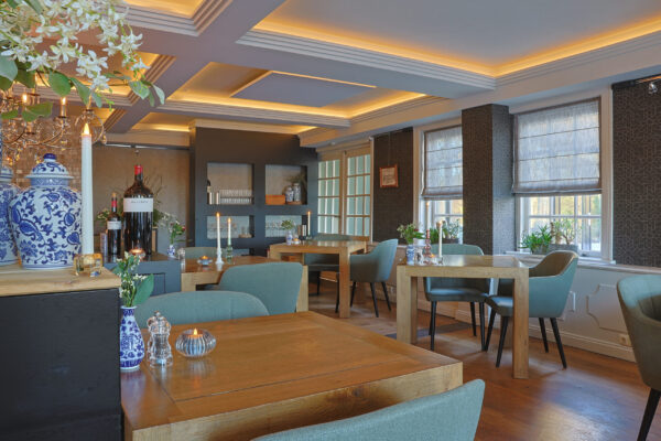 een sfeervol ingericht restaurant met een aantal 2 persoons tafels