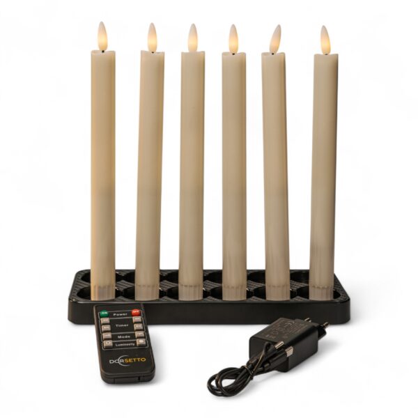 Home 12 Zestaw sześciu białych, ładowalnych i ściemnialnych świec obiadowych LED o wysokości 250 mm, ustawionych w czarnym świeczniku. Z przodu widoczny pilot zdalnego sterowania oraz adapter zasilania z przewodem, całość na białym tle.