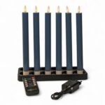 Sześć ciemnoszarych świec obiadowych LED o wysokości 250 mm, ładowalnych i ściemnialnych (zestaw 6 sztuk z funkcją timera), ustawionych w czarnym świeczniku. Z przodu znajduje się pilot zdalnego sterowania oraz adapter zasilania, całość na białym tle.