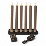 Sześć ładowalnych świec obiadowych LED o wysokości 250 mm stoi na czarnej podstawie; każda świeca ma płomieniowy, ściemnialny moduł LED. Z przodu widoczne są pilot zdalnego sterowania oraz zasilacz z przewodem do obsługi zestawu 6 świec z funkcją timera.