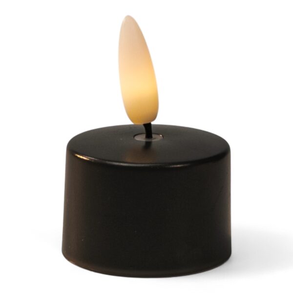 Mały czarny LED tealight z plastikowym płomieniem emitującym ciepłe, żółtawe światło.