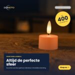 Zestaw 12 różowych podgrzewaczy LED (Ładowalne podgrzewacze LED różowe) świeci ciepłym światłem na ciemnej powierzchni. Podkreślenia w tekście: Altijd de perfecte sfeer, Voor thuis & horeca, 400 uur brandtijd, Shop nu. Nazwa marki Dorsetto jest wyświetlana u góry.
